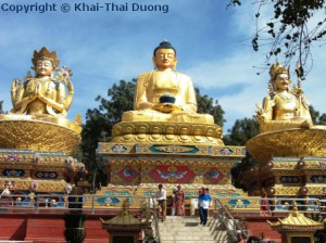 Ein Eingang wird von drei riesigen Buddha-Statuen bewacht.